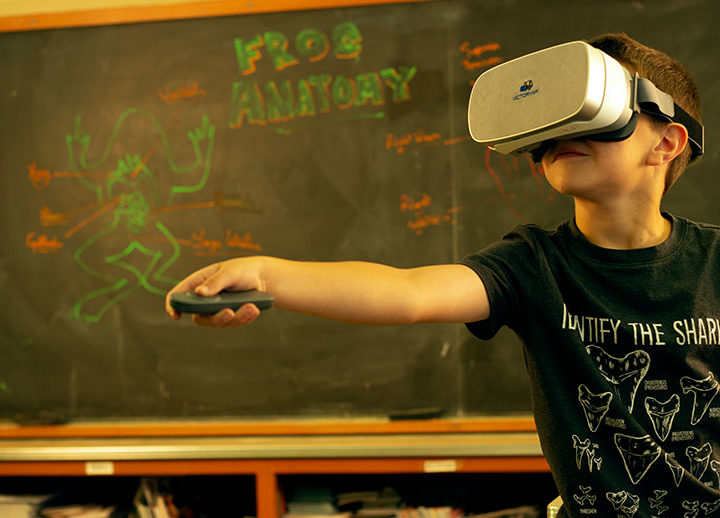 kid using virtual reality goggles in a classroom